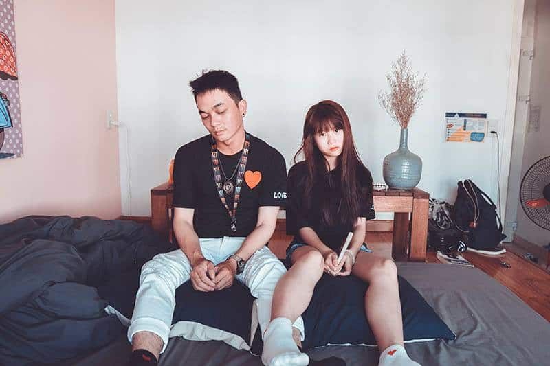 man and woman sitting on bed