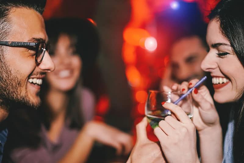 side view of man and woman drinking at the club