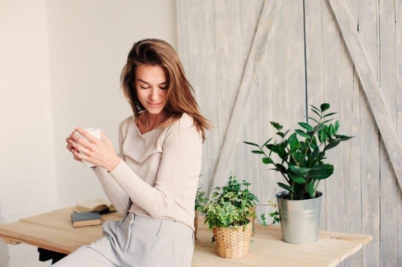 young woman relaxing at home with cup of coffee