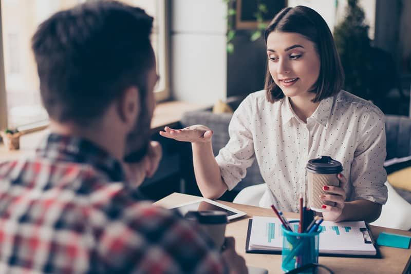 young woman talking to business man