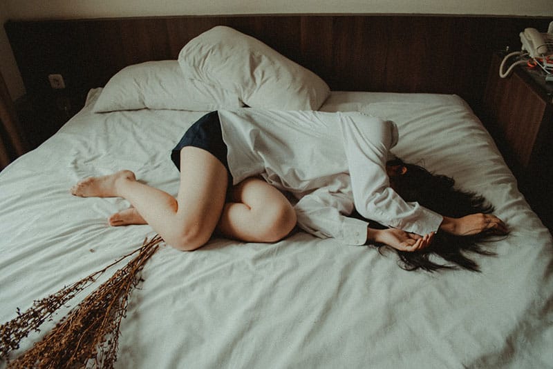 depressed woman laying on the bed