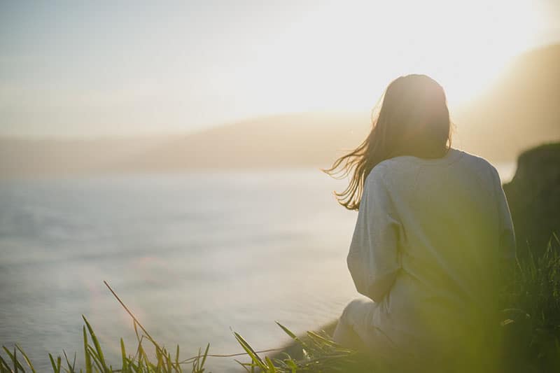 mindful woman sitting on the hill in silence