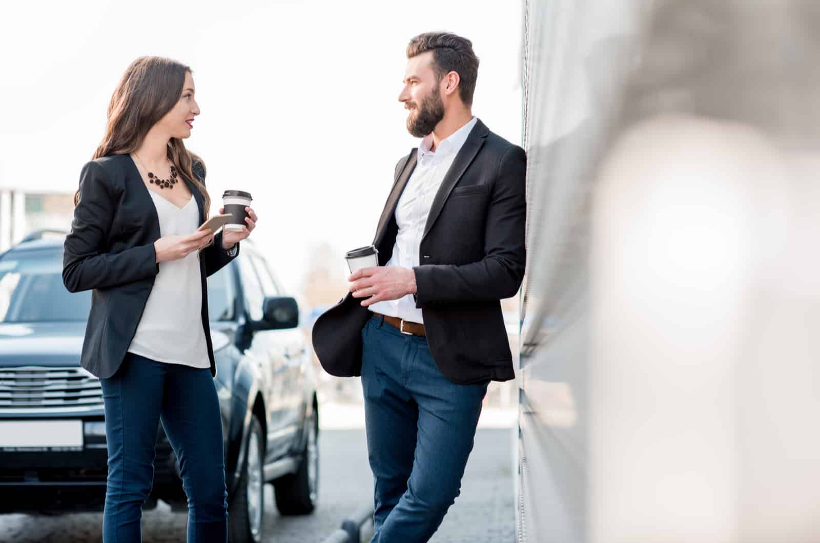 a man and a woman stand outdoors talking