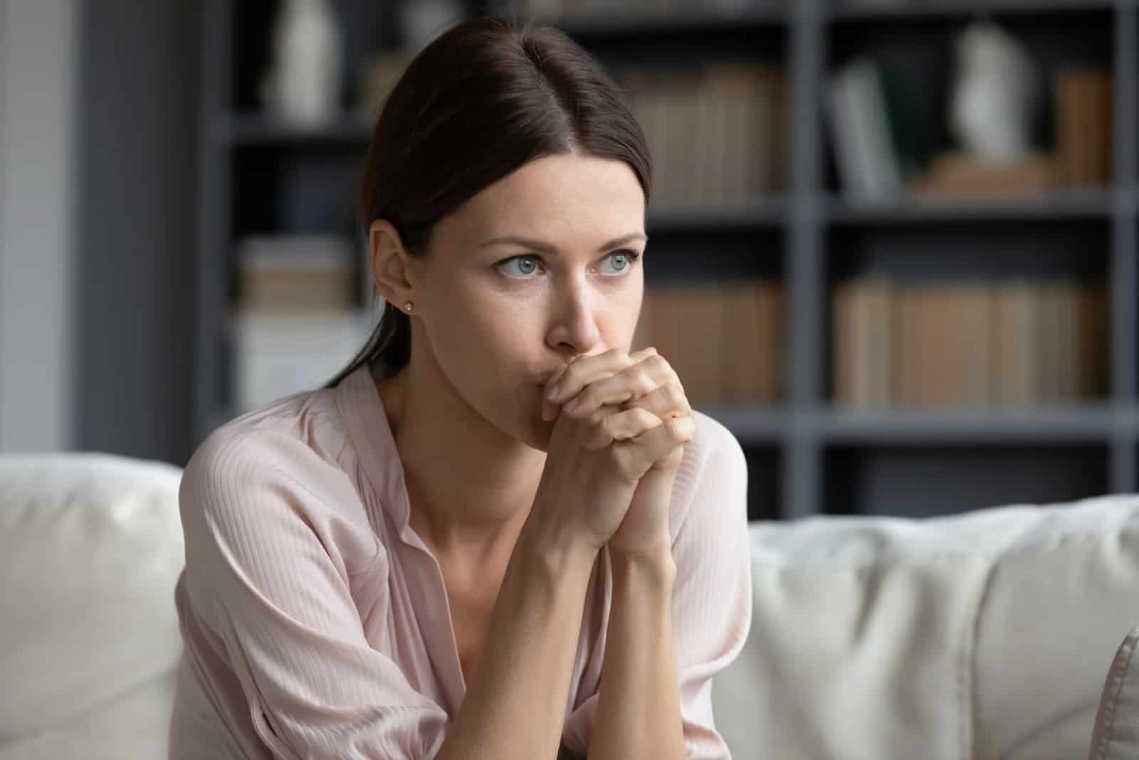 sad woman sitting in the living room and thinking