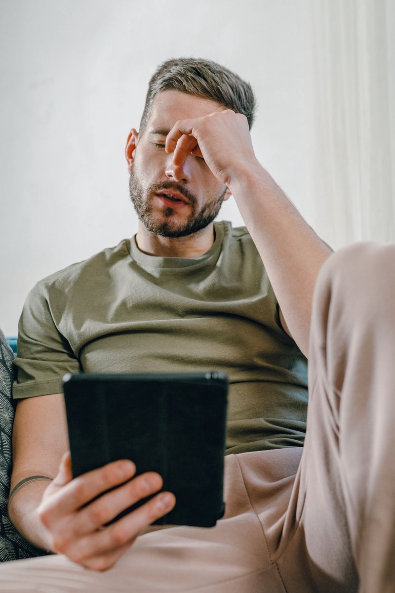A Distressed Man Sitting on a Couch · Free Stock Photo