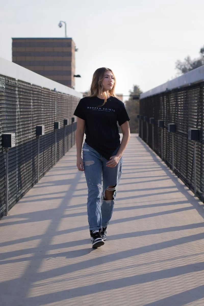 Woman in black crew neck t-shirt and blue denim jeans ...